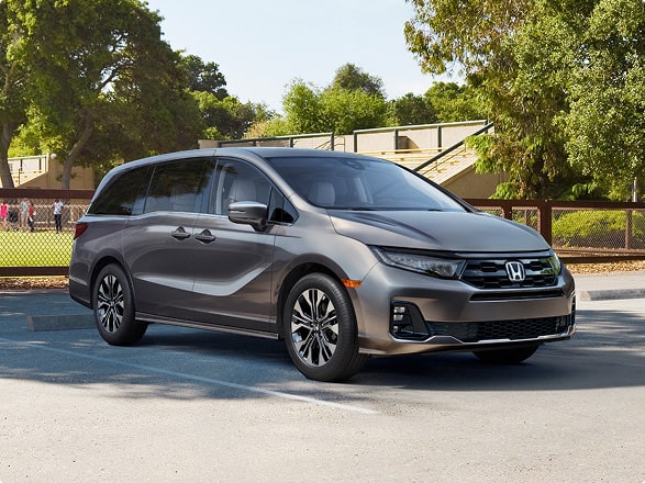 Vista frontal de la minivan Honda Odyssey Elite 2027 en Modern Steel Metallic estacionada al aire libre (minivan).