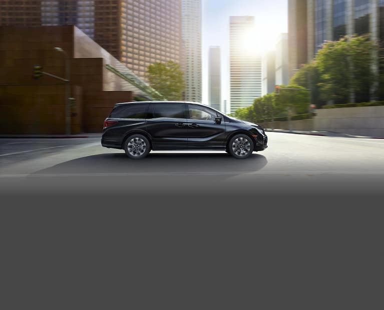 Honda Odyssey Elite 2027 conduciendo por un entorno urbano.